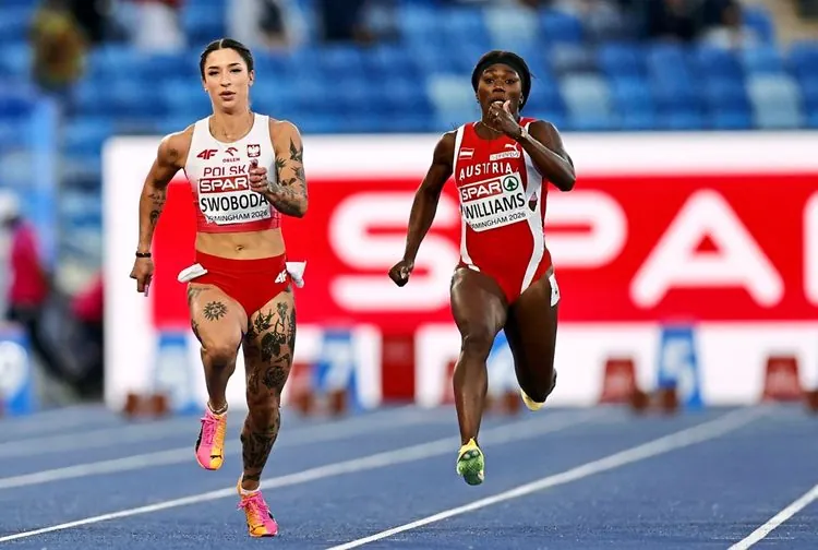 Zwei Sprinterinnen, Ewa Swoboda aus Polen (links) und Christania Williams aus Österreich (rechts), laufen während eines 100-Meter-Halbfinales bei den Leichtathletik-Europameisterschaften 2026 in Birmingham auf einer blauen Laufbahn. Im Hintergrund ist das Stadion und ein Werbebanner zu sehen.